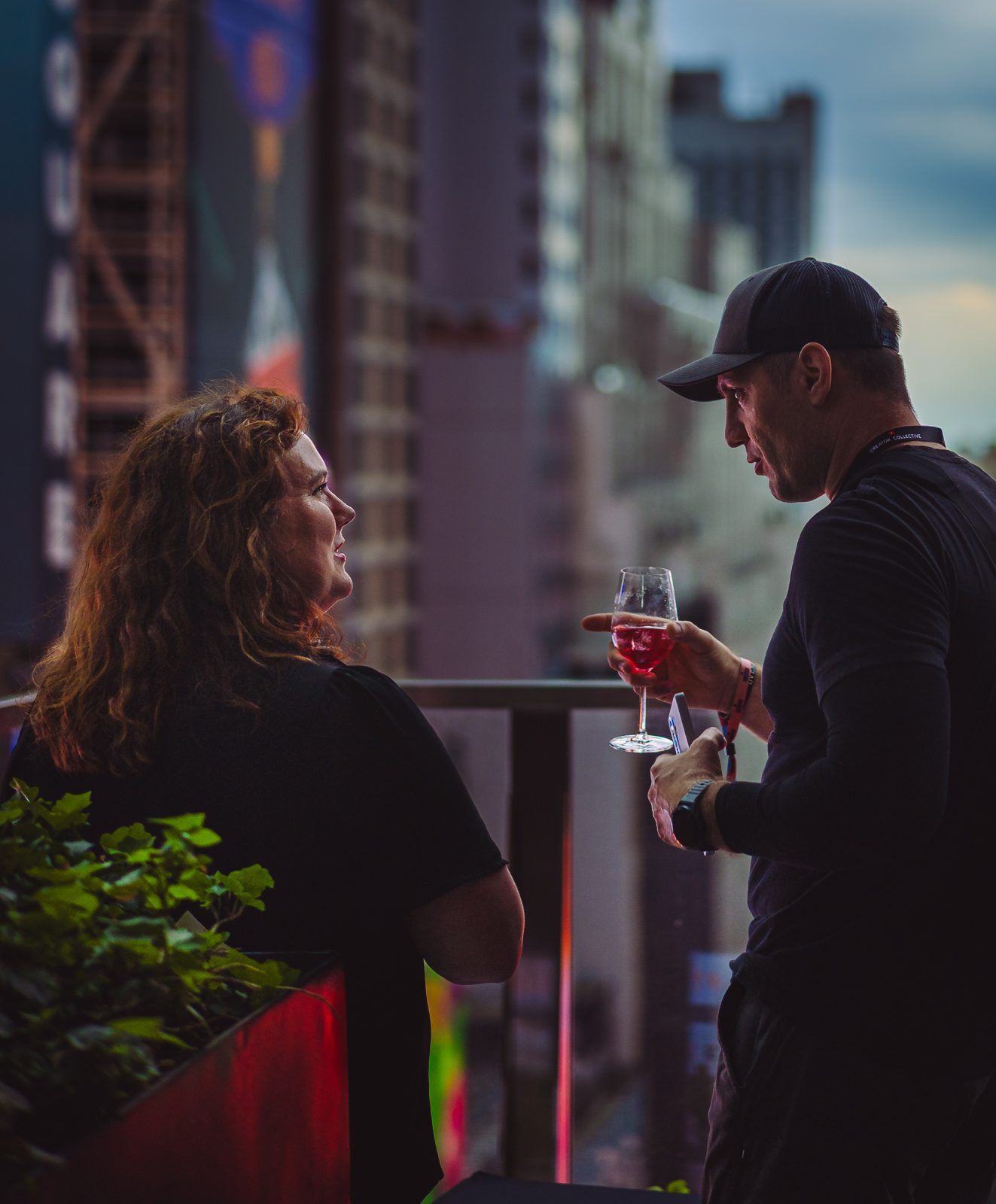 Candid rooftop conversation above Times Square at dusk
