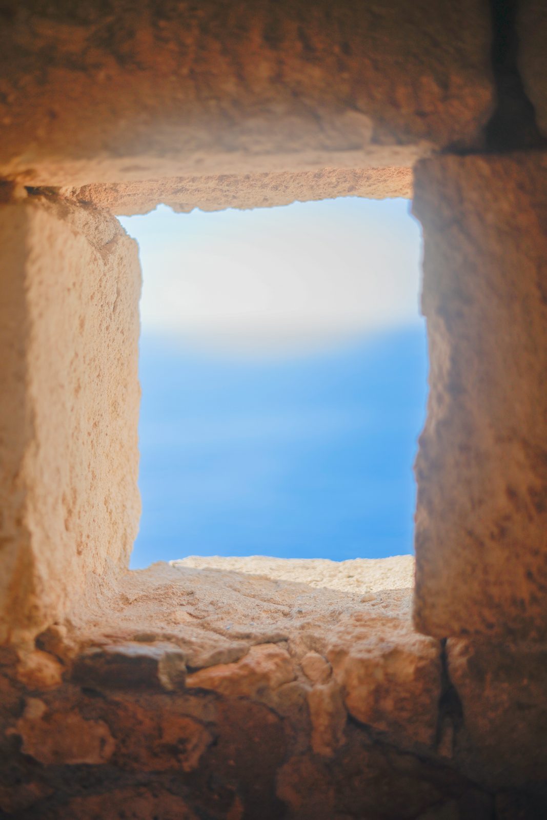 The sea framed through an ancient stone window